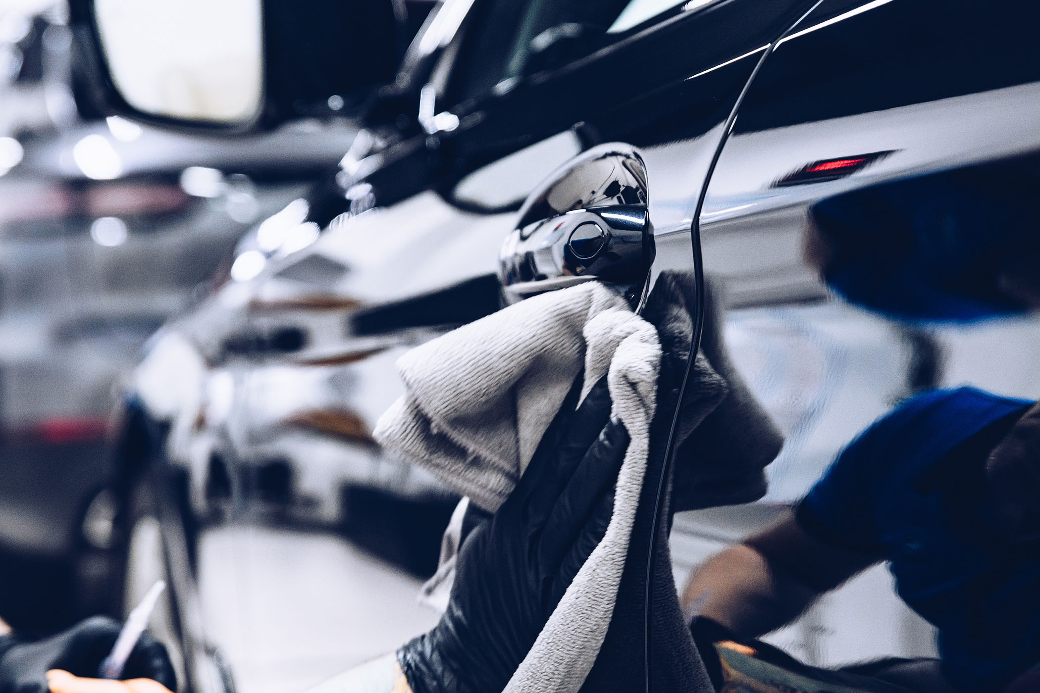 Detailer hand-polishing a vehicle to a mirror finish